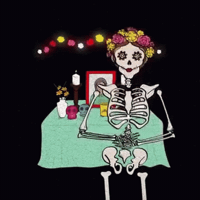 Skeleton Sitting At Table With Skulls And Flowers GIF