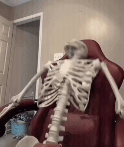 Skeleton Sitting In Red Chair GIF