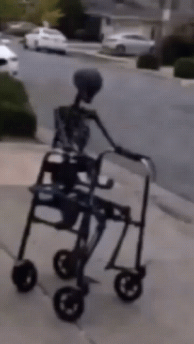Skeleton Walking With Walker On Sidewalk GIF