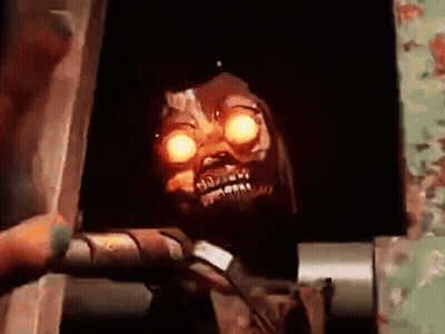 Skeleton With Glowing Eyes In Dark Room GIF