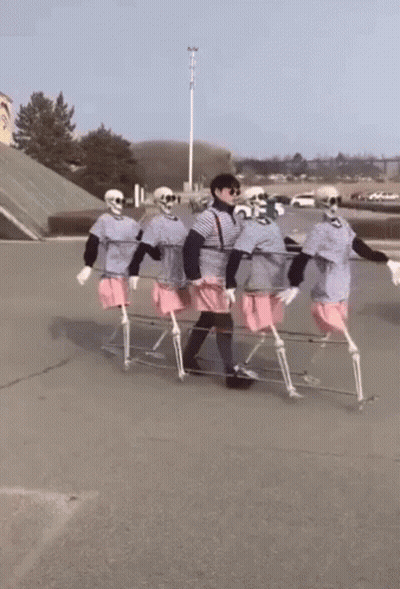 Skeletons Carrying Person On Stretcher GIF