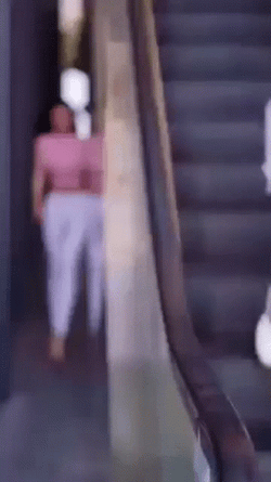 Skinny Woman Passing By Escalator GIF