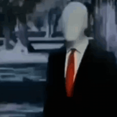 Slender Man In Suit And Tie Standing In Room GIF