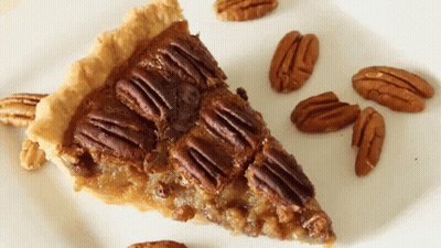 Slice Of Pecan Pie On Plate With Pecans GIF