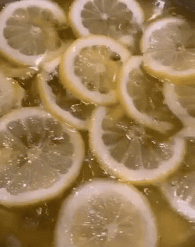 Sliced Lemons In Pot Of Liquid GIF