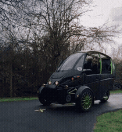 Small Black Car With Green Wheels Parked On Road GIF