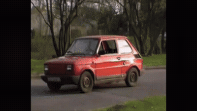 Small Red Car Driving Down Road GIF