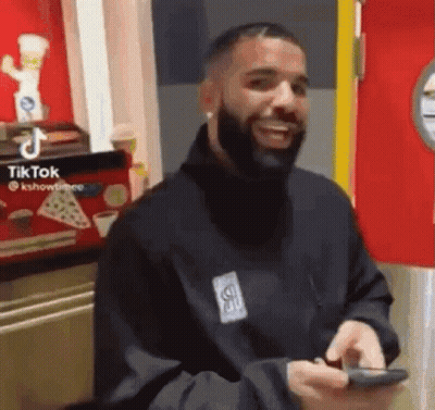 Smiling Bearded Man With Cell Phone In Restaurant GIF