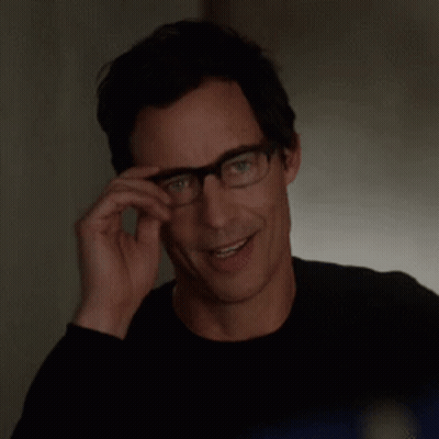 Smiling Man Adjusting Glasses in Black Shirt