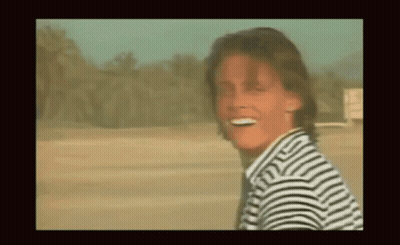 Smiling Man In Striped Shirt In Desert GIF