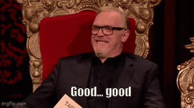 Smiling Man In Suit And Glasses Holding Book Saying Good GIF
