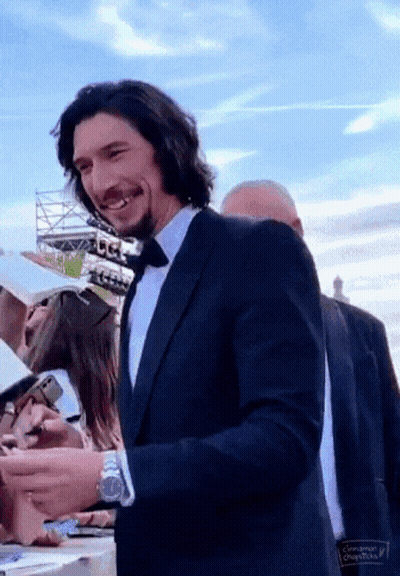 Smiling Man In Suit And Tie Signing Autographs GIF