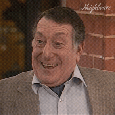 Smiling Man In Suit By Neighbours Brick Wall GIF
