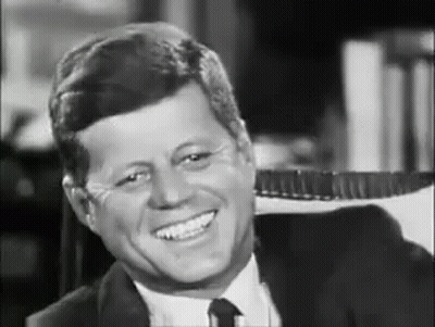 Smiling Man In Suit Sitting In Chair GIF