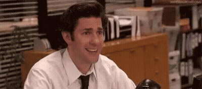 Smiling Man In White Shirt And Black Tie At Desk GIF