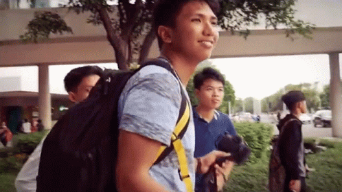 Smiling Man With Backpack Walking With Two Men GIF