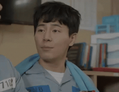 Smiling Prisoner Next To Another In Cell GIF