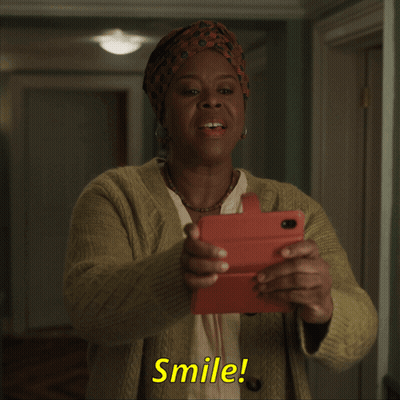 Smiling Woman Holding Cell Phone Saying Smile GIF