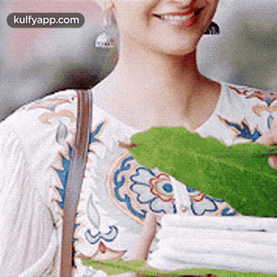 Smiling Woman Holding Green Leaf GIF