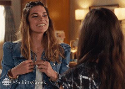Smiling Woman In Denim Jacket Talking To Another Woman GIF