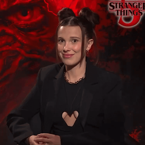 Smiling Woman In Front Of Strange Things GIF