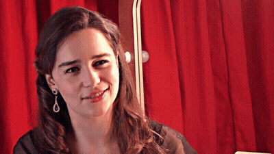 Smiling Woman With Earrings And Red Curtain GIF