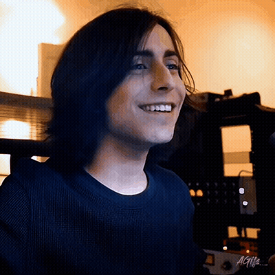 Smiling Young Man With Long Hair And Black Shirt GIF