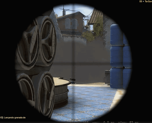 Sniper Scope Showing Stack Of Barrels And Building In Distance GIF