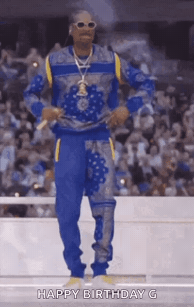 Snoop Dogg Is Dancing In Front Of A Crowd In A Stadium While Wearing A Blue And Yellow Outfit . GIF