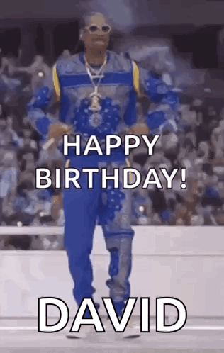 Snoop Dogg Is Dancing In Front Of A Crowd While Wearing A Blue And Yellow Outfit . GIF