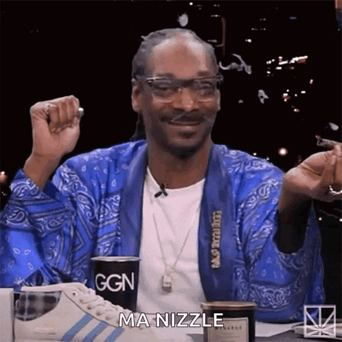 Snoop Dogg Is Sitting At A Table With A Cup Of Coffee And A Cigarette . GIF