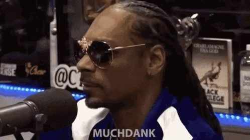 Snoop Dogg Is Sitting In Front Of A Microphone Wearing Sunglasses And Saying Muchdank GIF