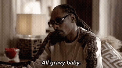 Snoop Dogg Is Sitting On A Couch In A Living Room Talking On A Cell Phone . GIF