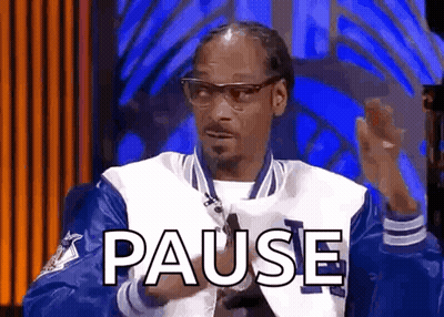 Snoop Dogg Is Wearing A Blue And White Jacket And Glasses While Sitting In Front Of A Blue Background . GIF