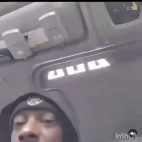 Snoop Dogg Is Wearing A Hoodie And A Hat While Sitting In The Driver 'S Seat Of A Car . GIF