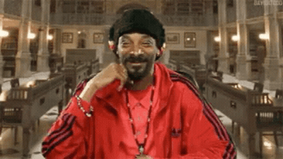 Snoop Dogg Is Wearing A Red Jacket And A Black Hat While Sitting In A Church . GIF