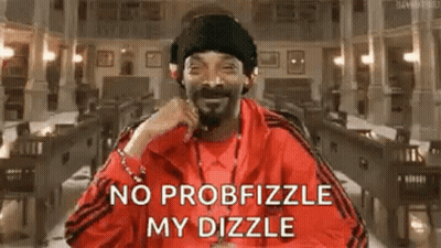 Snoop Dogg Is Wearing A Red Jacket And A Black Hat While Sitting In A Library . GIF