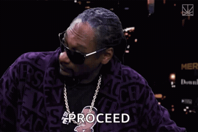 Snoop Dogg Is Wearing Sunglasses And A Purple Jacket With The Word Proceed Written On It GIF