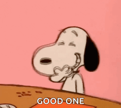 Snoopy Is Sitting At A Table Covering His Mouth With His Hand And Laughing . GIF