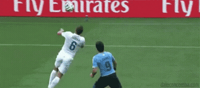 Soccer Goalie Jumping To Catch Ball While Player Blocks GIF