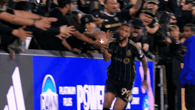 Soccer Player Celebrating Goal Under Power Banner