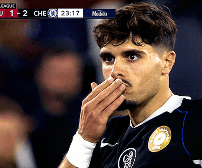 Soccer Player Covering Mouth In Front Of Modelo Scoreboard GIF