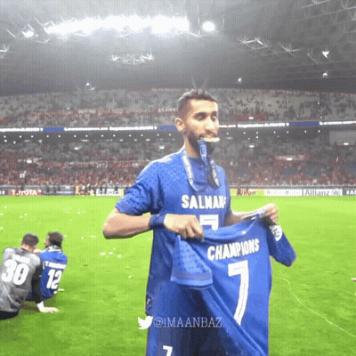 Soccer Player Holding Up Shirt Saying Champions GIF