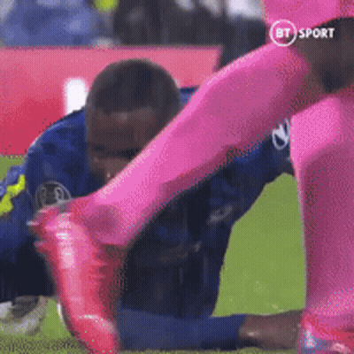 Soccer Player In Blue Tackled By Player In Pink GIF