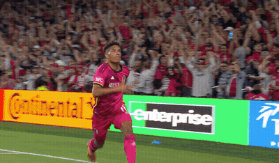 Soccer Player In Pink Jersey Running Past Enterprise Sign GIF