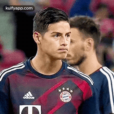 Soccer Player In Purple And Red Adidas Jersey Standing Next To Player GIF