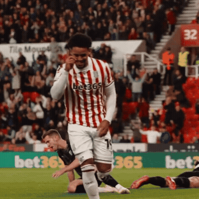 Soccer Player In Red And White Jersey Running Past Birmingham Van Centre Ad GIF