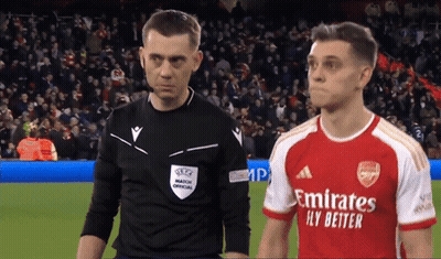 Soccer Player In Red Emirates Fly Better Jersey Next To Referee GIF