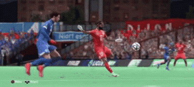 Soccer Player In Red Jersey Kicking Ball While Blue Player Defends GIF
