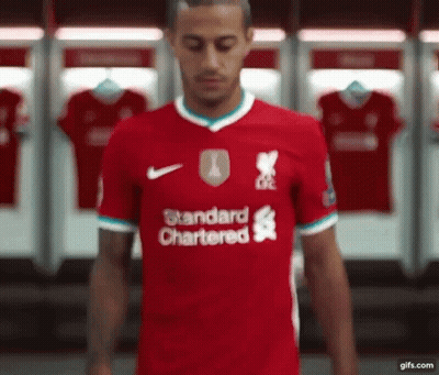 Soccer Player In Red Standard Chartered Jersey In Locker Room GIF